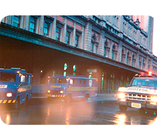 Carros-fortes do Grupo Protege em frente a um edifício histórico, 1971